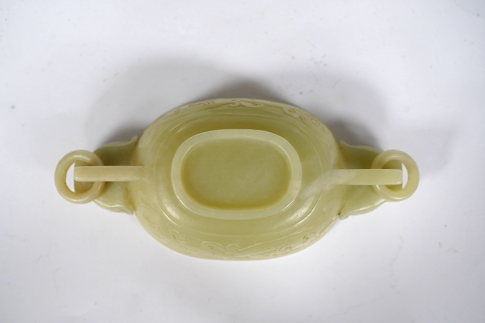 A Chinese archaistic pale green bowenite jade twin handled cup on stand, cup 11.5cm wide. Condition - cup good, stand good